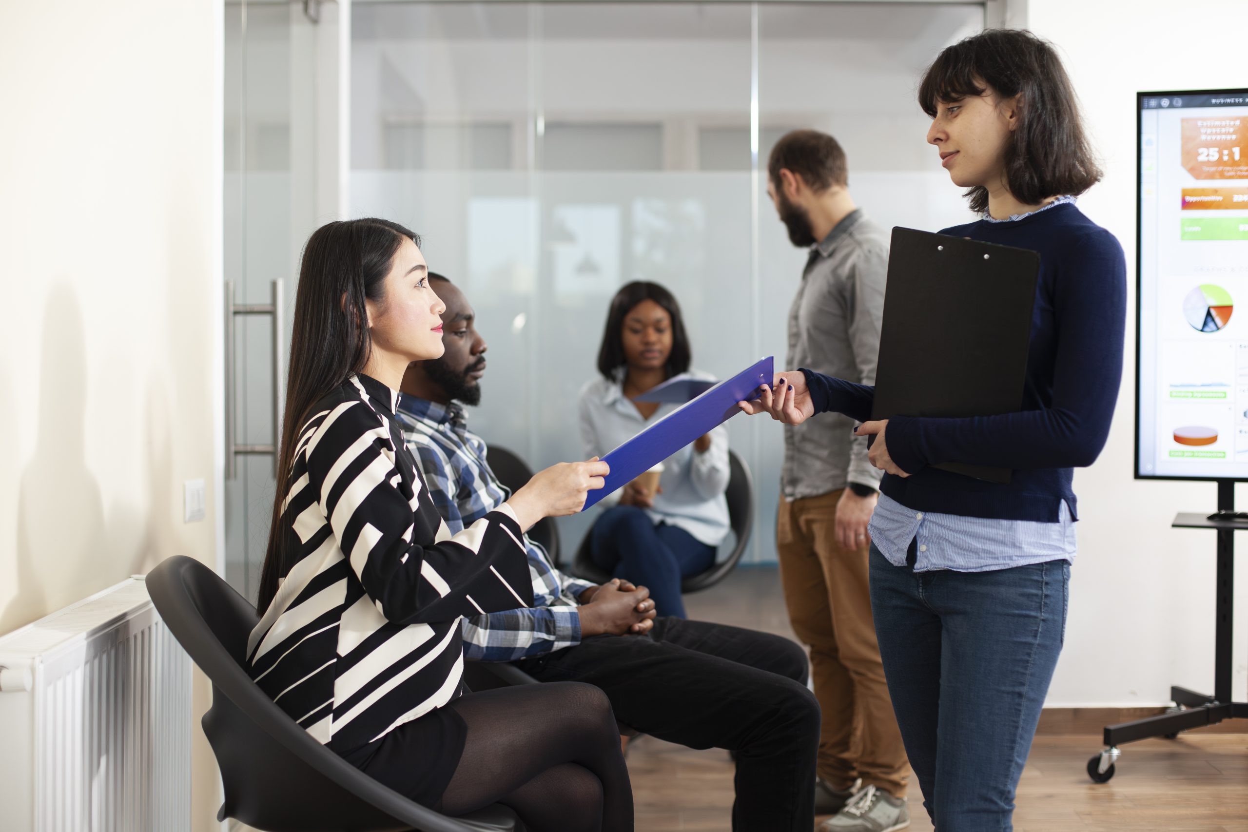 hr-employee-collects-cv-from-asian-lady-1.jpg
